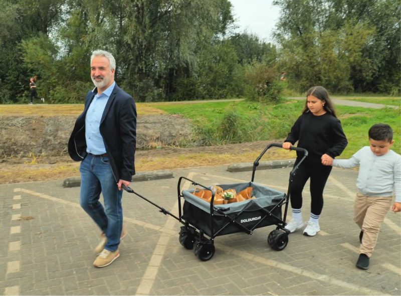 Parkta çocuklarla kullanılan katlanabilir taşıma arabası